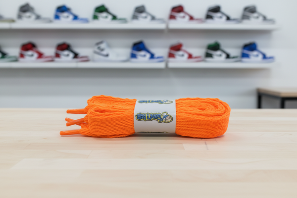 a pair of flat neon orange 20mm wide shoelaces